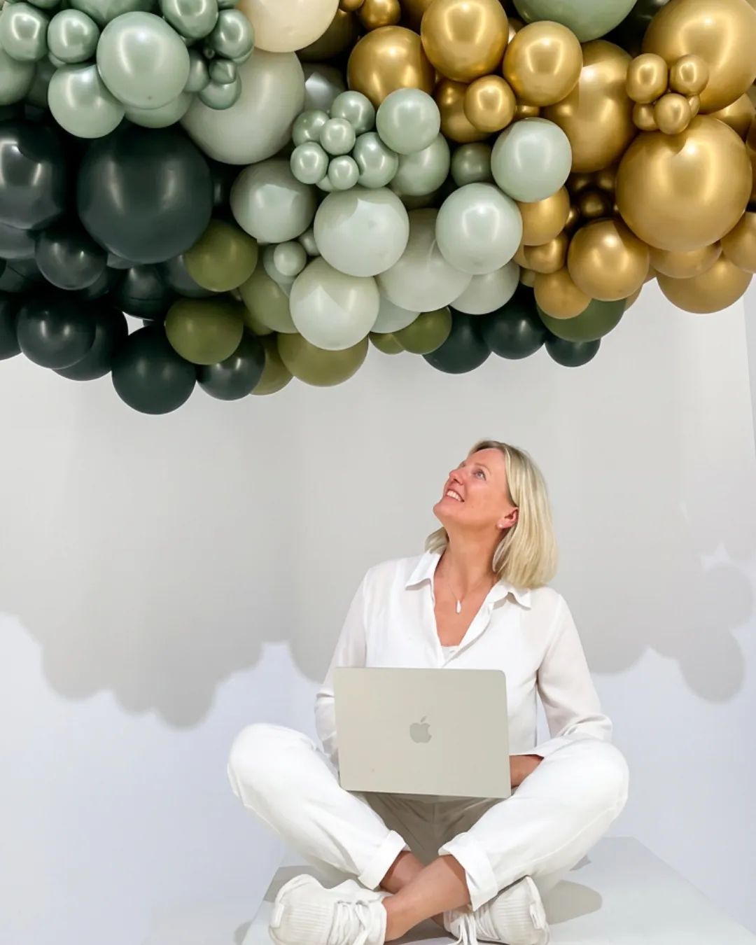 Olga Reyes-Busch, KI-Beraterin und Gründerin der HeadUpHigh GmbH, schaut hoffnungsvoll nach oben zu einer Ballon-Wolke